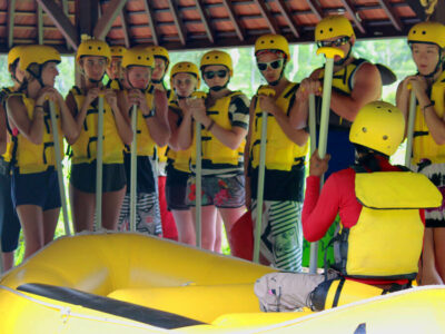 Peserta rafting mendengarkan briefing keselamatan di Bali.