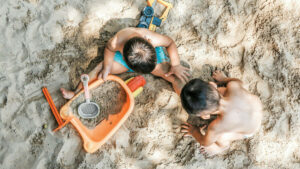 Anak-anak bermain pasir di pantai Bali