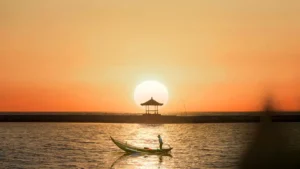 Sunrise di Pantai Sanur dengan perahu nelayan dan gazebo Bali