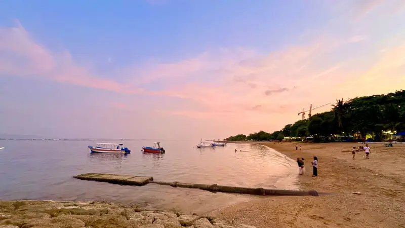 Pantai Sanur Bali dengan ombak tenang dan pasir putih, ideal untuk liburan keluarga