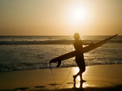 Peselancar di Pantai Batu Bolong saat matahari terbenam