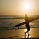 Peselancar di Pantai Batu Bolong saat matahari terbenam