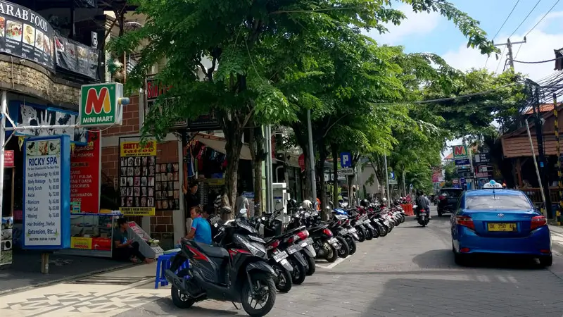 Street view Jalan Legian, menampilkan berbagai toko dan sepeda motor.