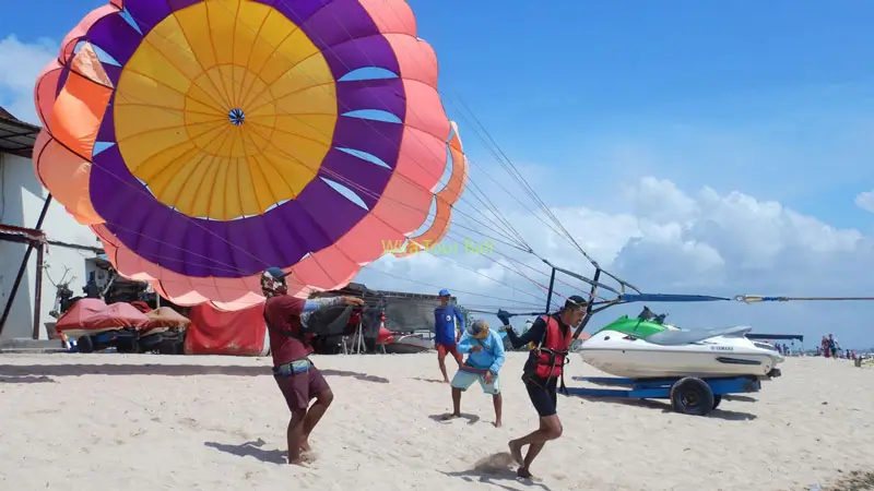 Parasailing lepas landas dan mendarat di pantai di Bali