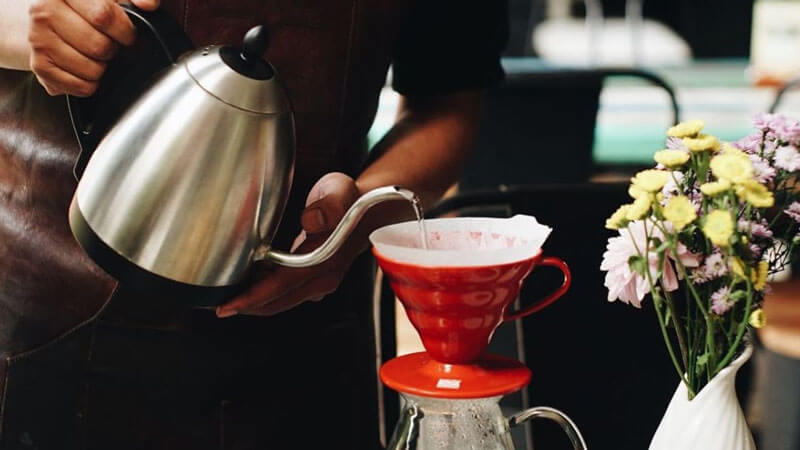 Pembuatan kopi dengan proses tuang yang presisi di The Coffee Library Kayu Aya.