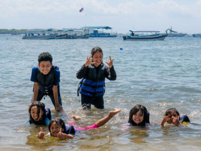 Anak-anak Bersenang-senang di Pantai Bali dengan Pakaian Water Sport