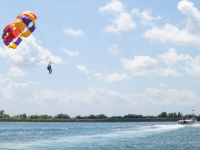 Peserta-peserta parasailing menikmati pemandangan laut biru di atas Tanjung Benoa, Bali.