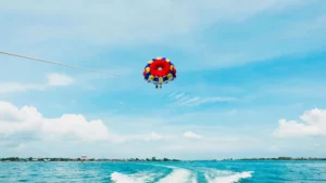 Wisatawan menikmati parasailing di pantai Bali.